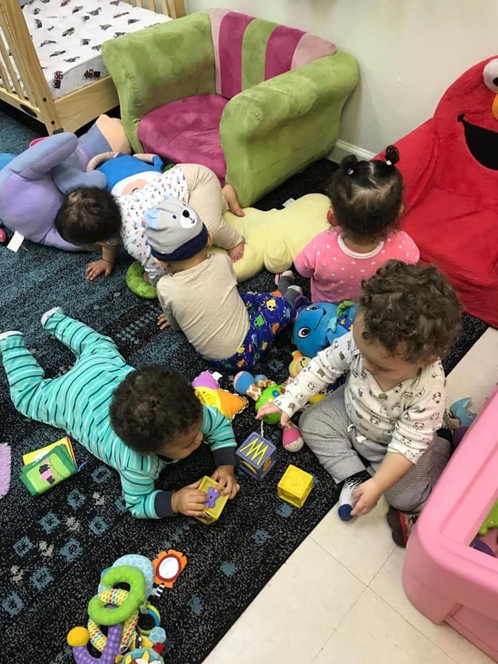 Multiple children playing with toys on a rug
