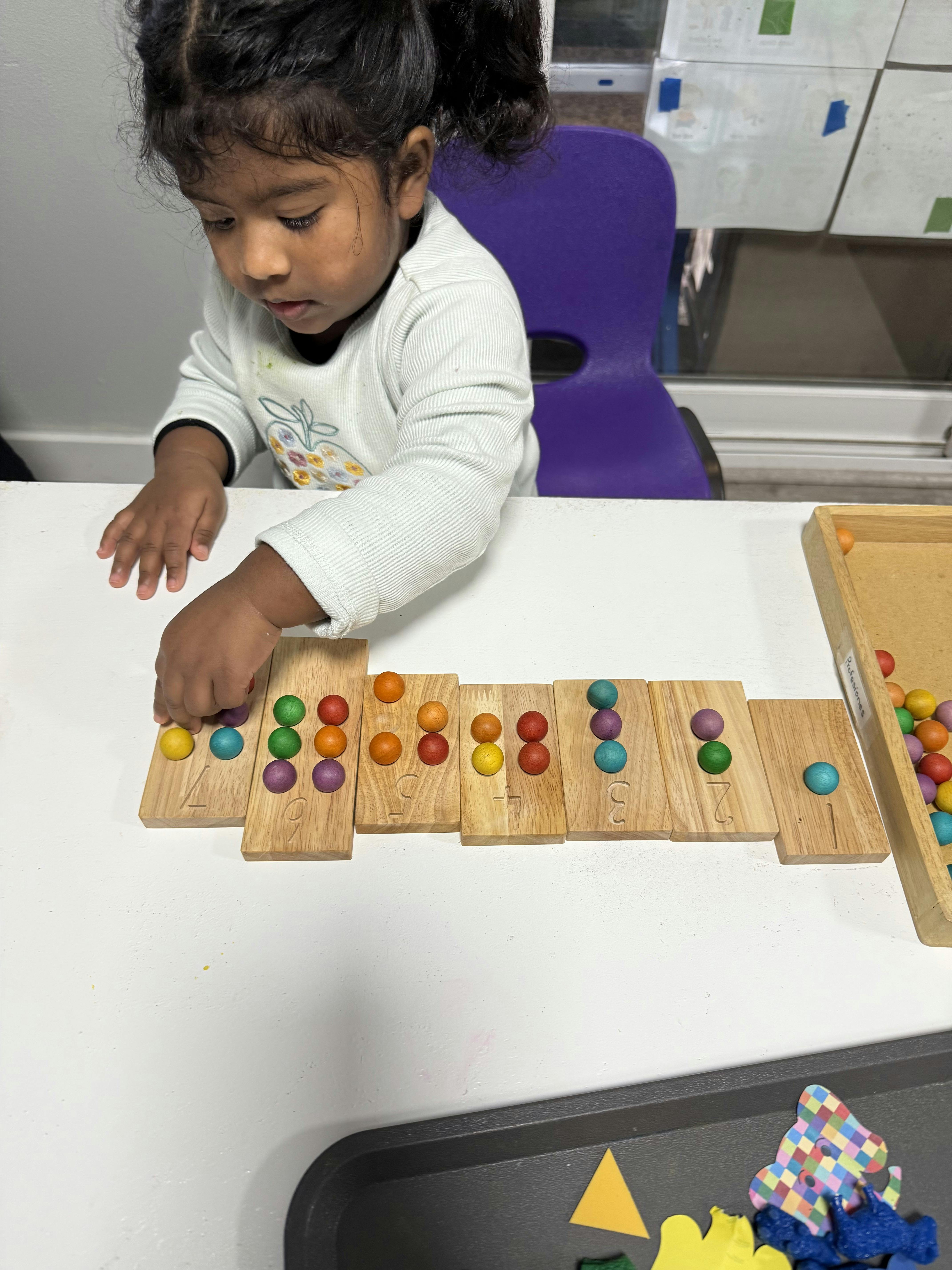 Child playing with colorful wooden counting blocks