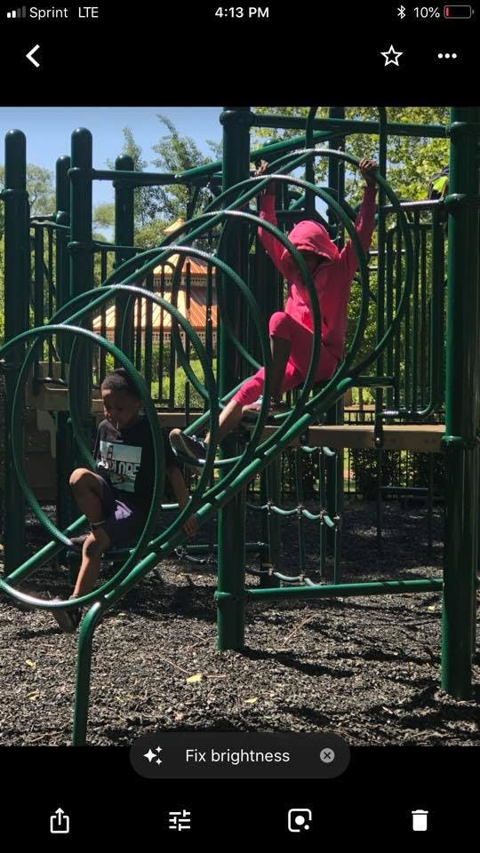 Two children on playground climbing equipment