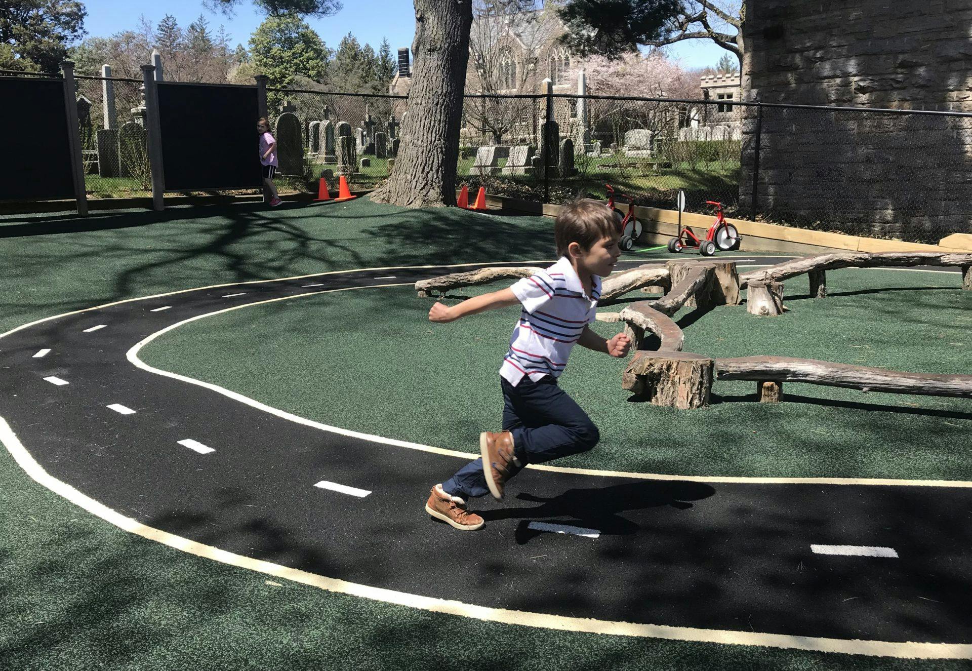 Child running on a playground with a painted road
