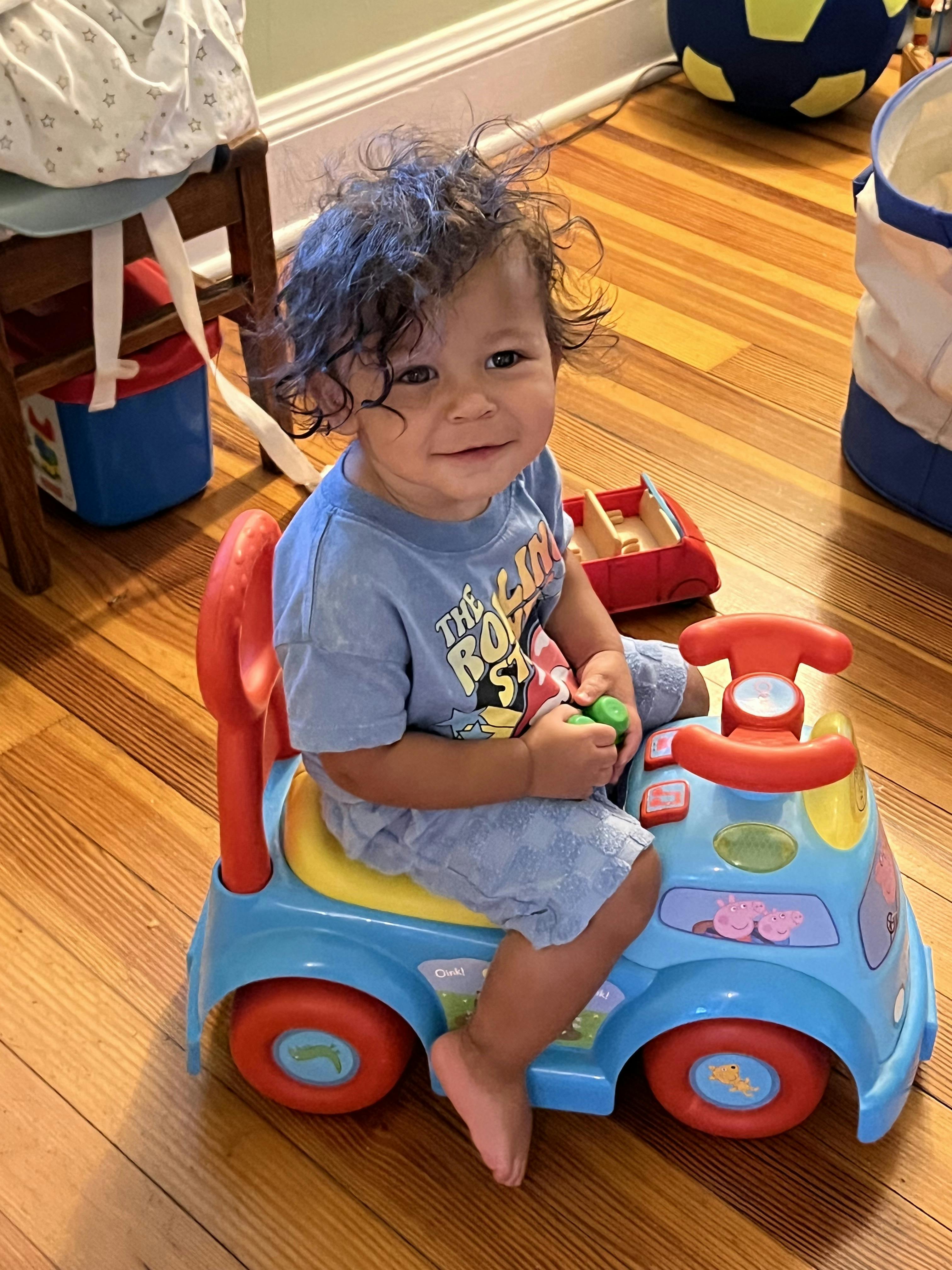 Child sitting in a toy car