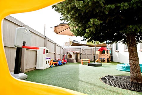 Outdoor playground with various play structures and a basketball hoop