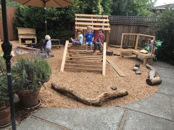 Children playing on wooden structures in a playground