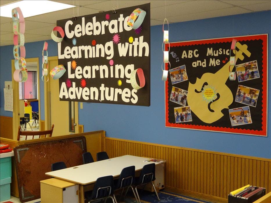 Classroom with "Celebrate Learning with Learning Adventures" and "ABC Music and Me" signs