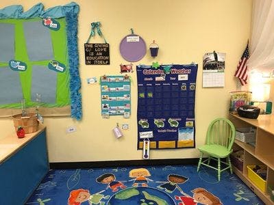Classroom with a calendar, weather chart, and children's rug