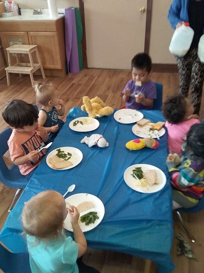 Children eating at a table with plates of food