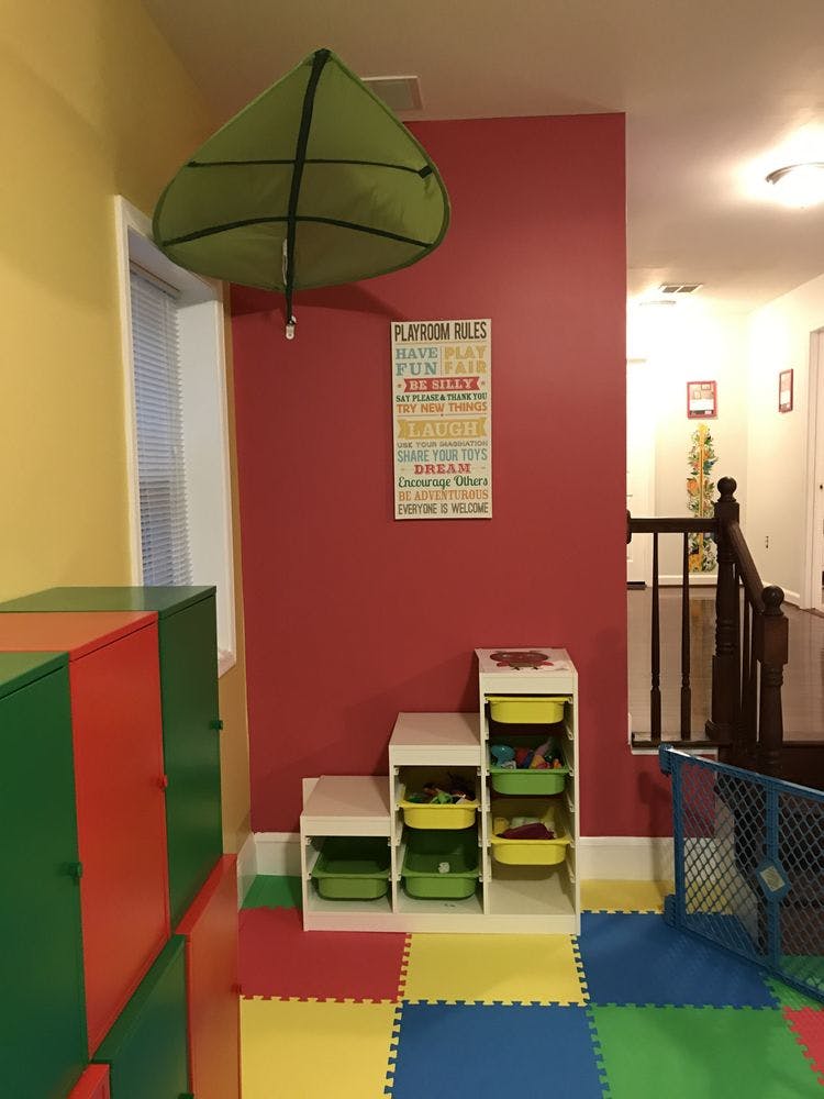 Playroom with organized storage bins and a wall sign listing playroom rules