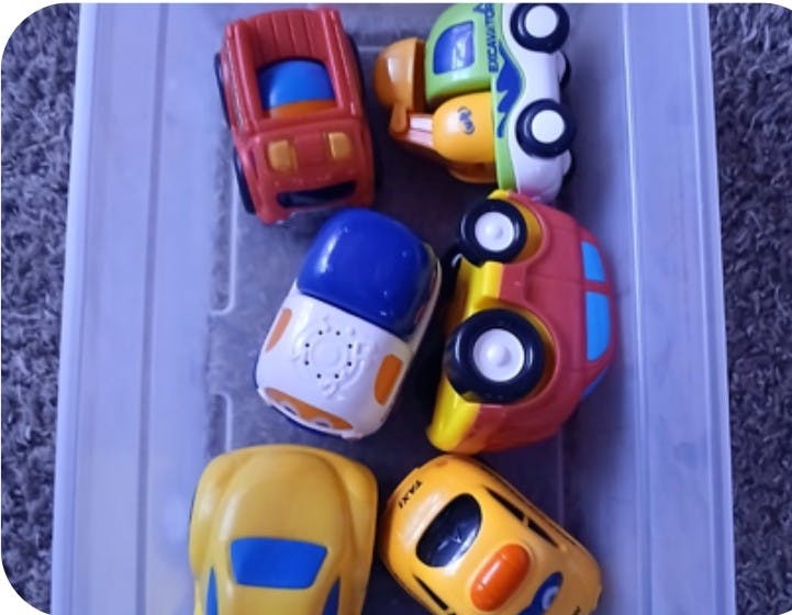 Several toy vehicles in a container
