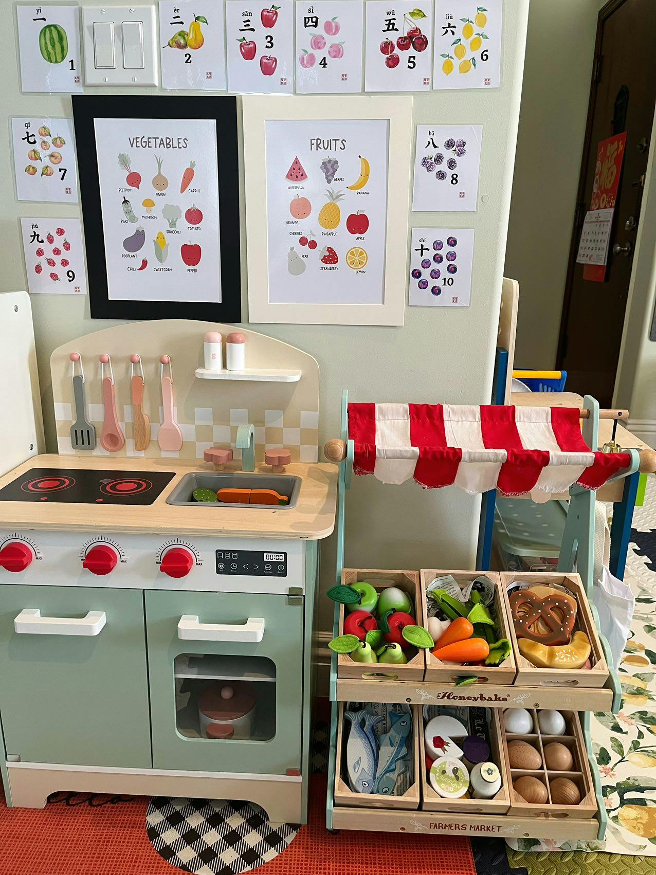 Play kitchen and market stand with toy fruits and vegetables