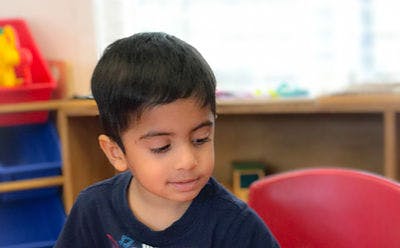 Child looking down in a classroom