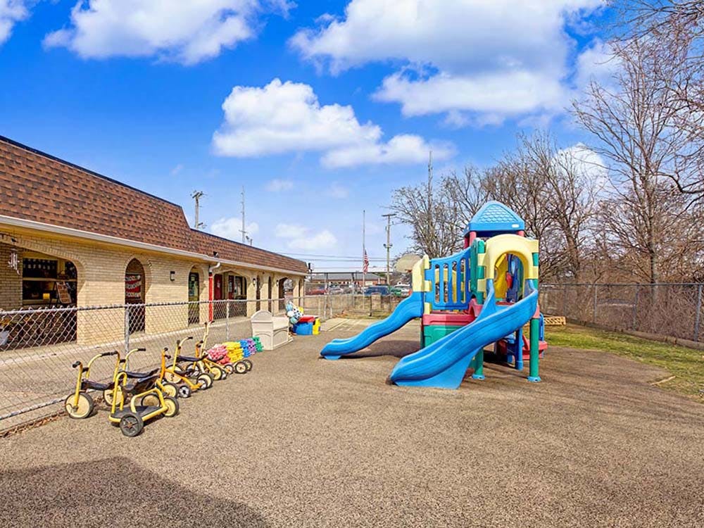 Playground with a colorful slide structure and tricycles
