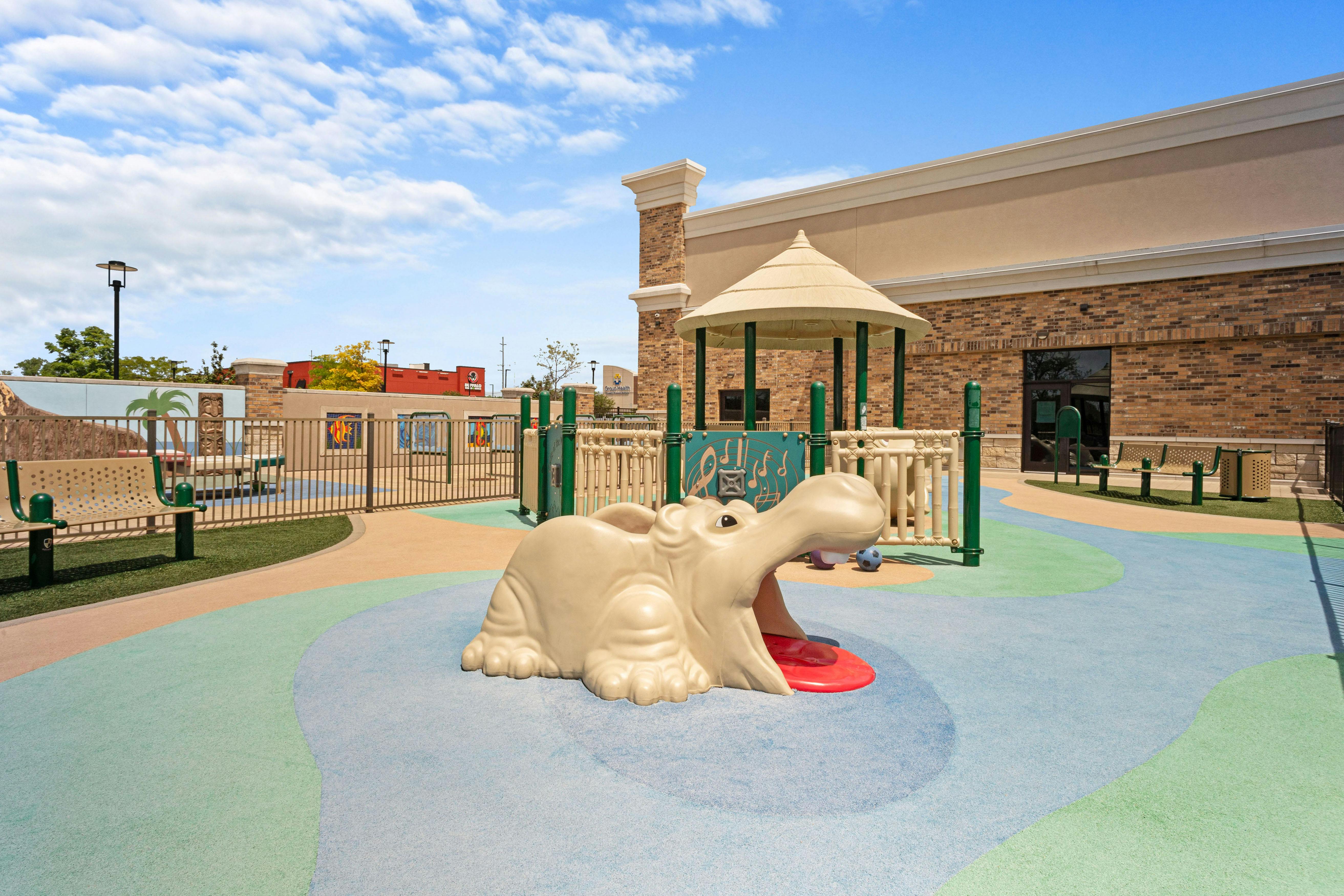 A hippopotamus playground climber on a colorful soft surface