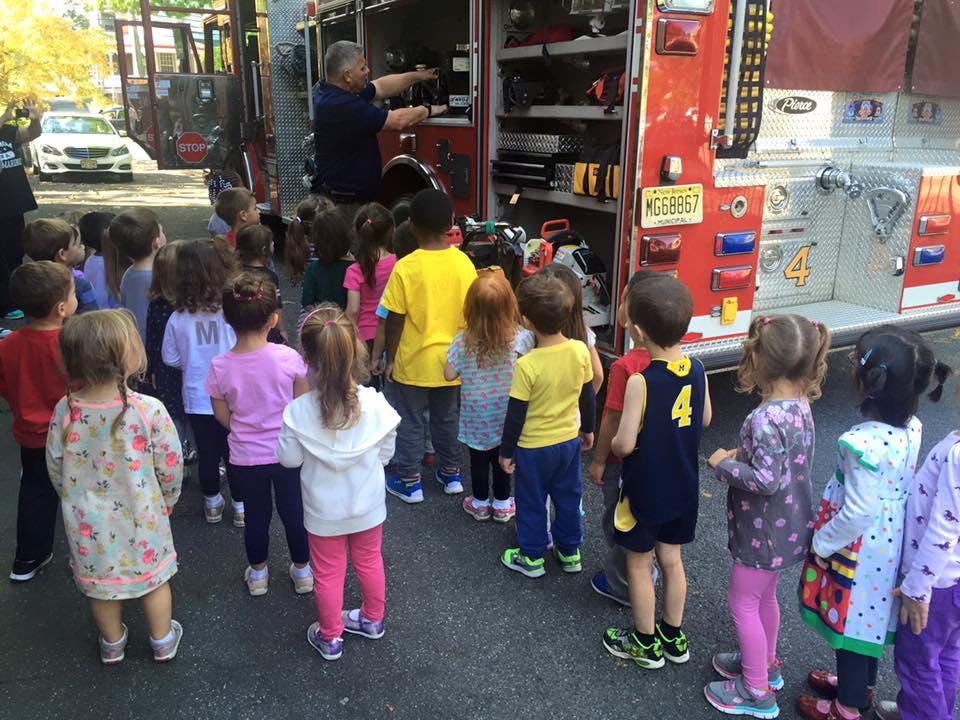 Adult showing children equipment on a fire truck