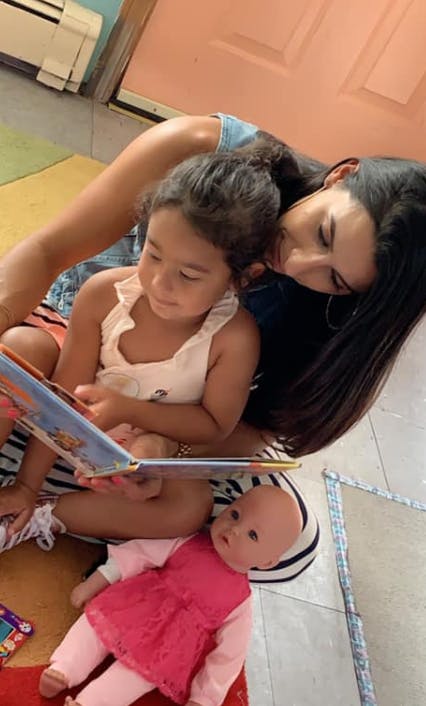 Person and child reading a book together