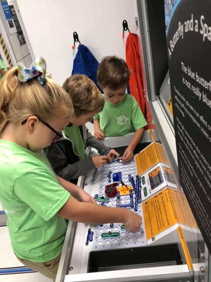 Three children working on an electronics project