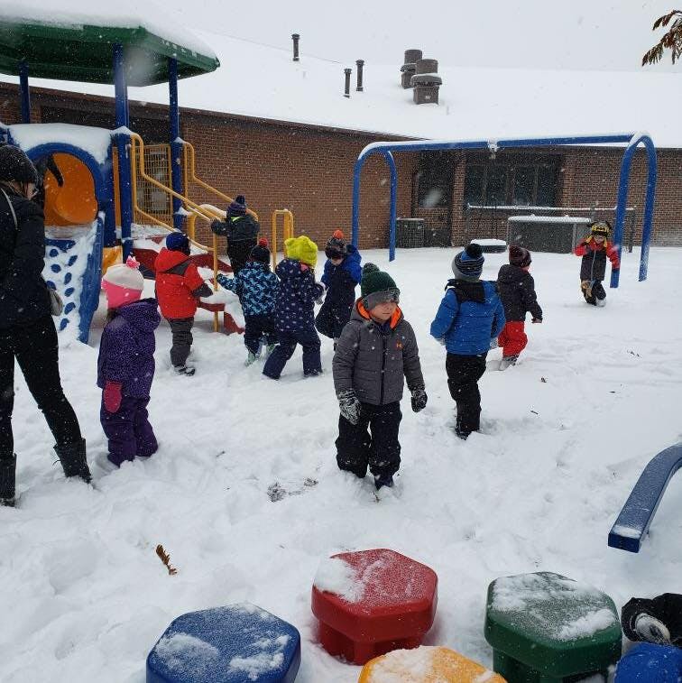 Children playing in snow on a playground