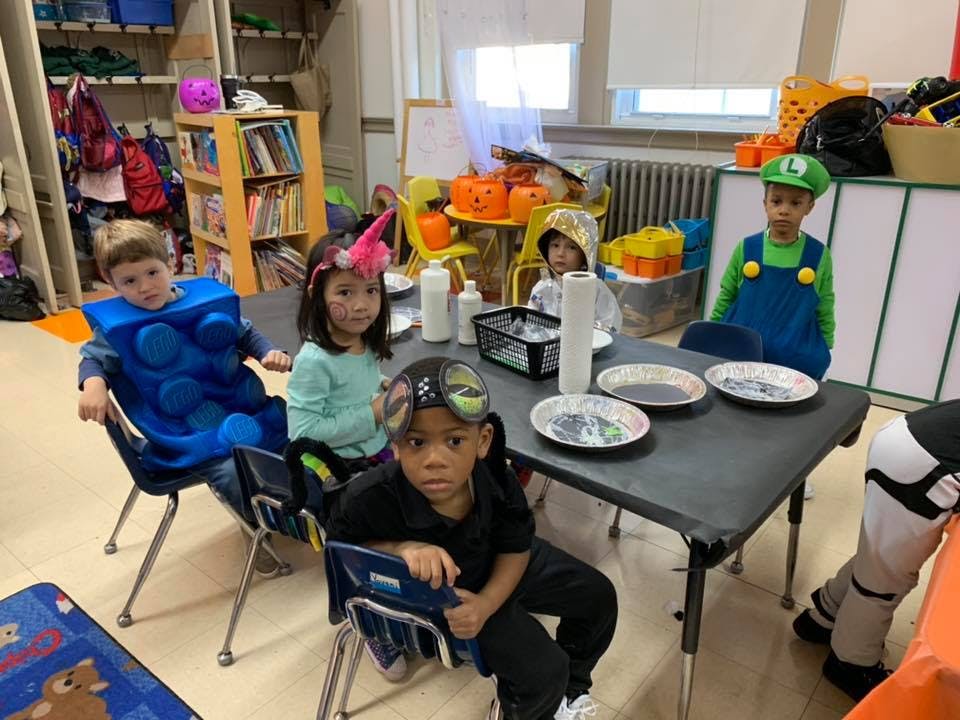 Children in costumes sitting around a table