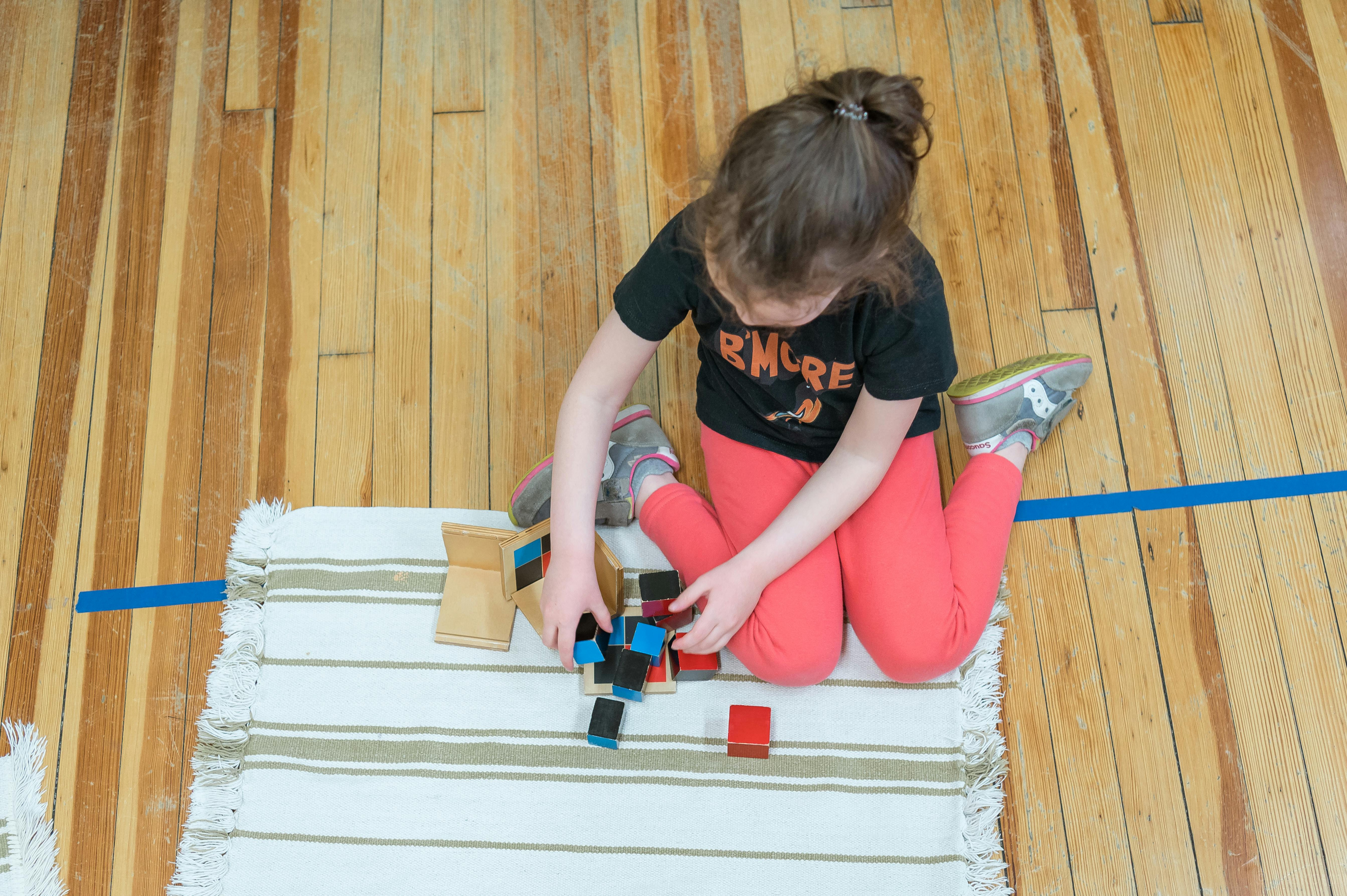 Child playing with blocks on a rug