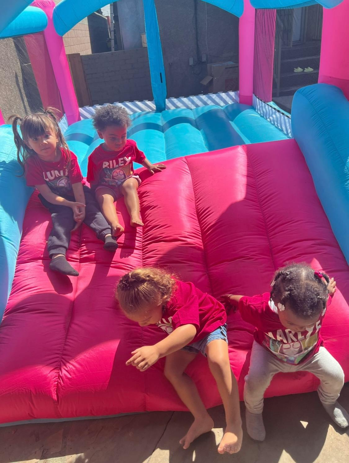 Four children playing on an inflatable bounce house