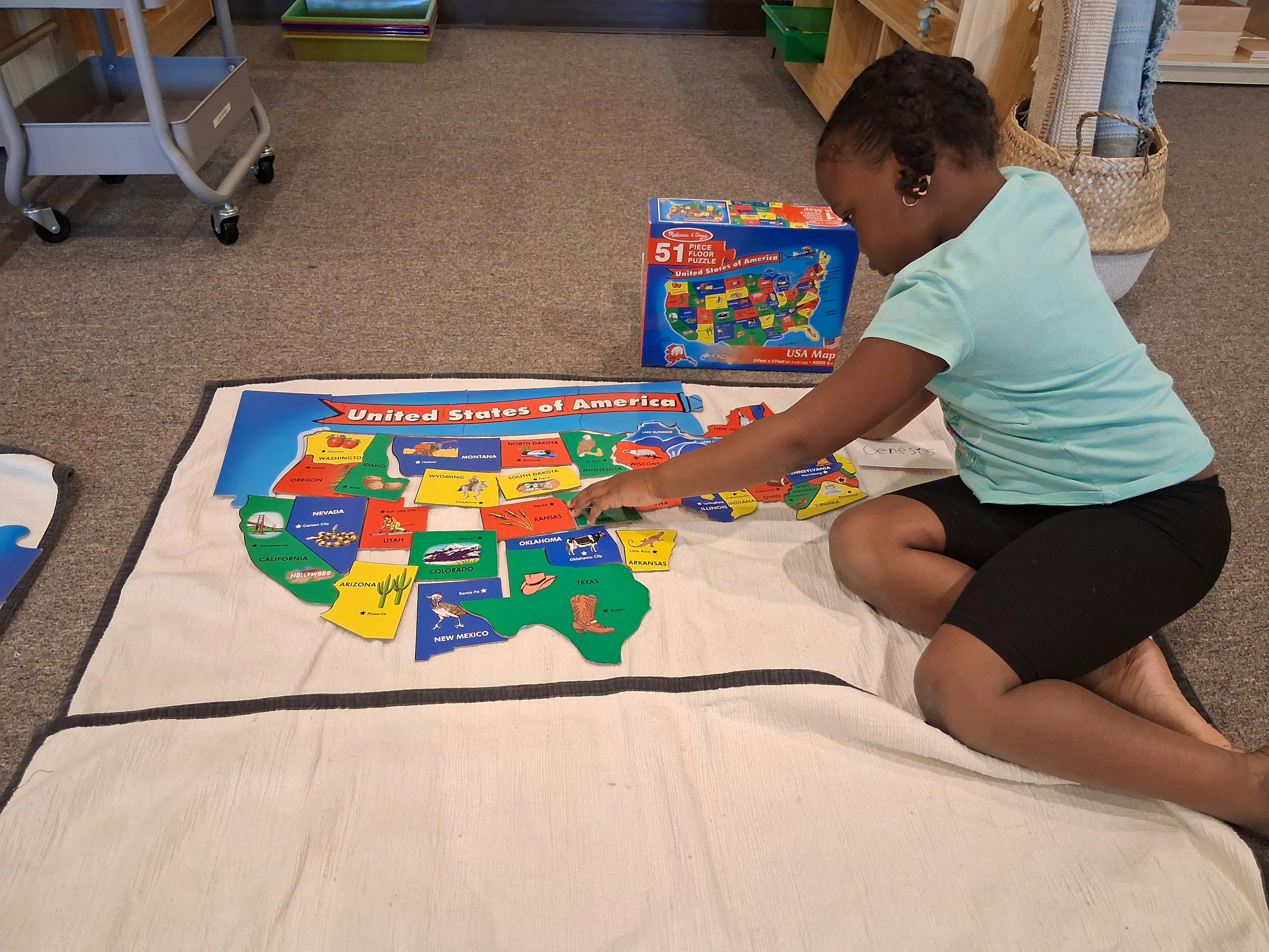 Child playing with a United States of America map puzzle