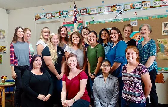 Group of people posing in a classroom