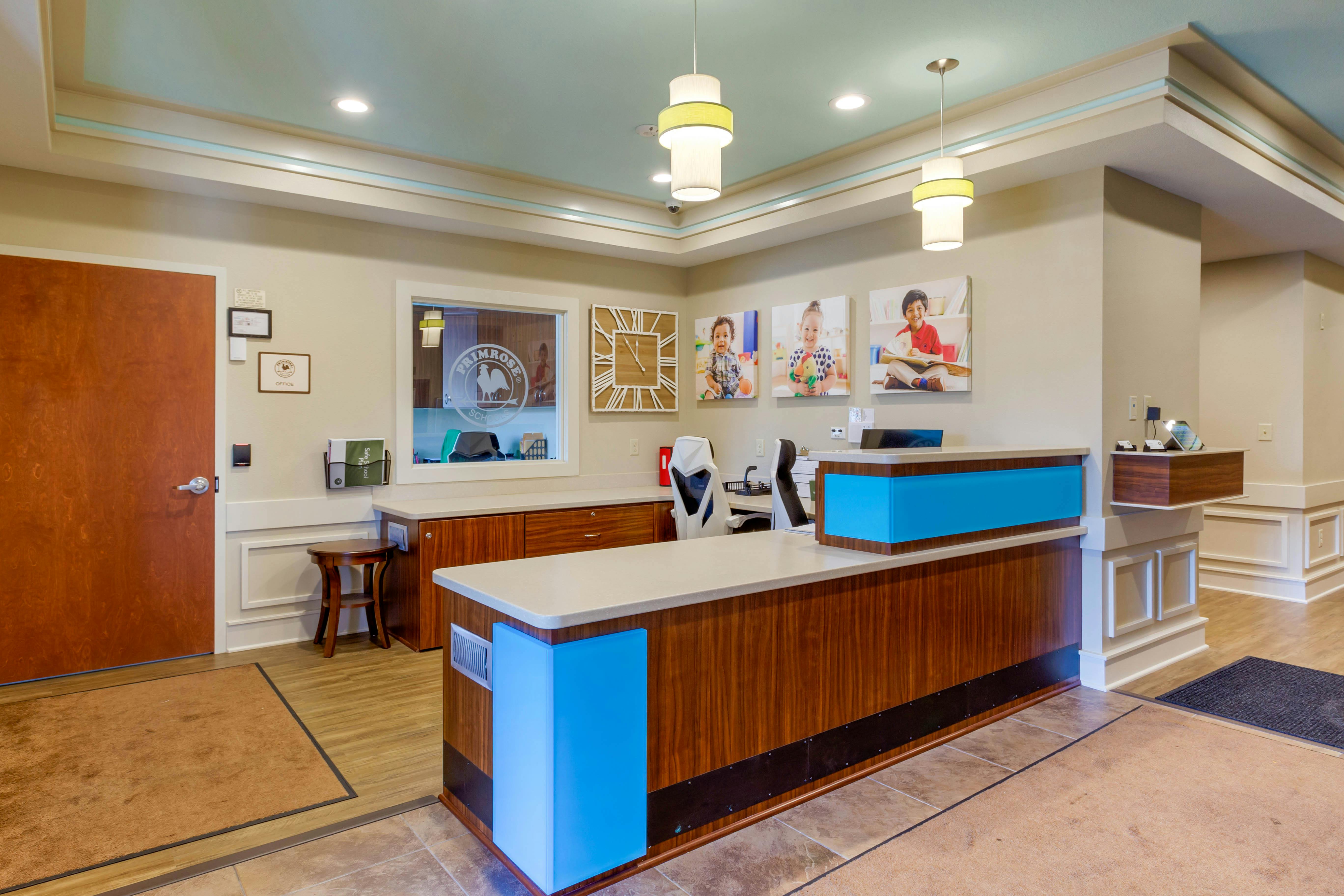 Reception area with a blue and wood reception desk, pictures of children on the wall