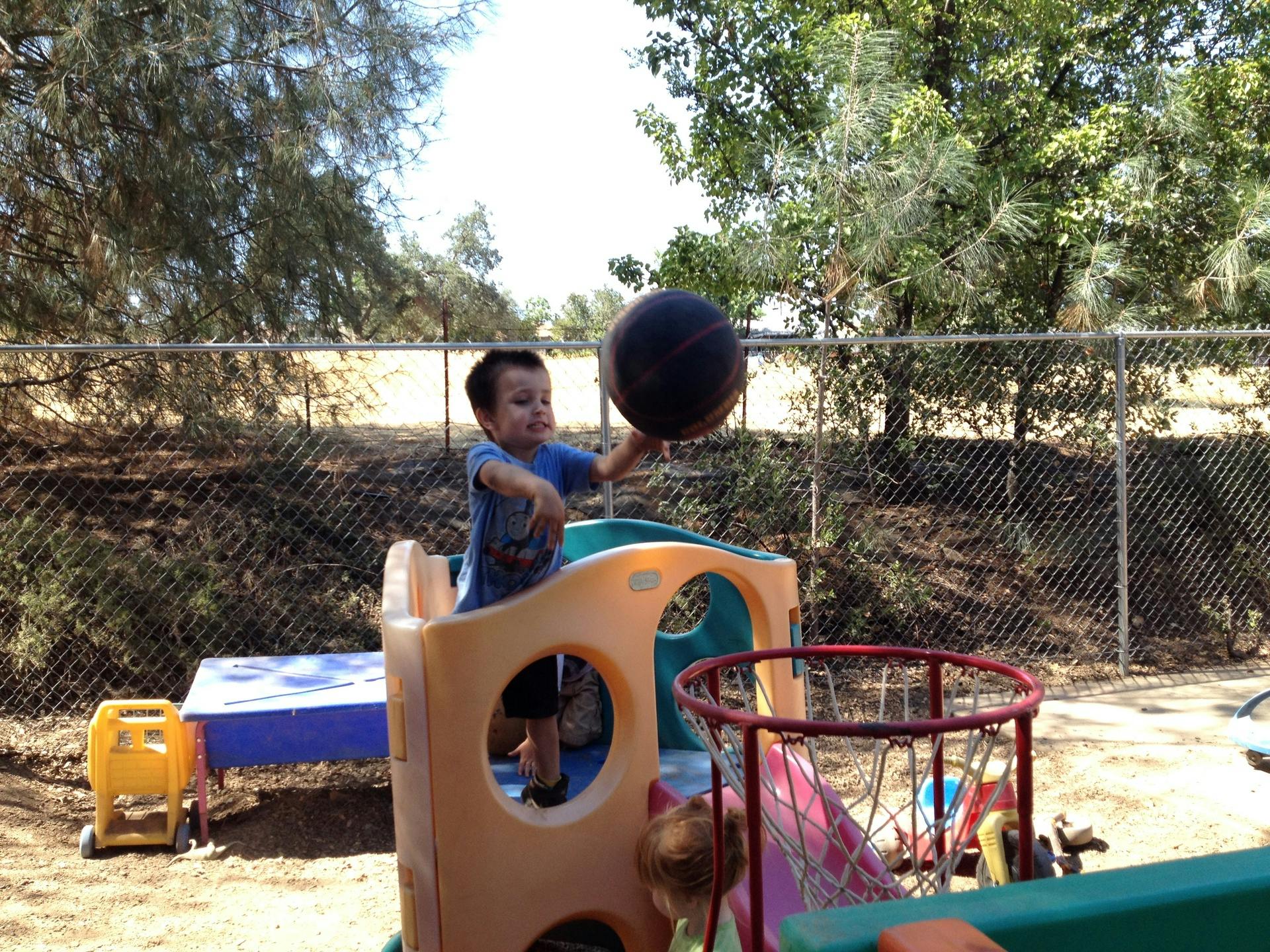 Child playing with a basketball on a playground