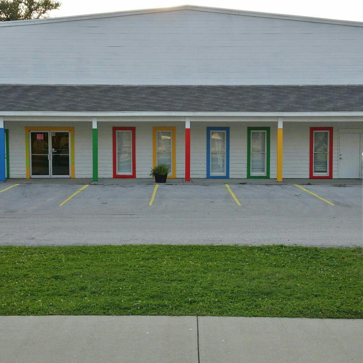 Building with multiple colorful doors and parking spaces