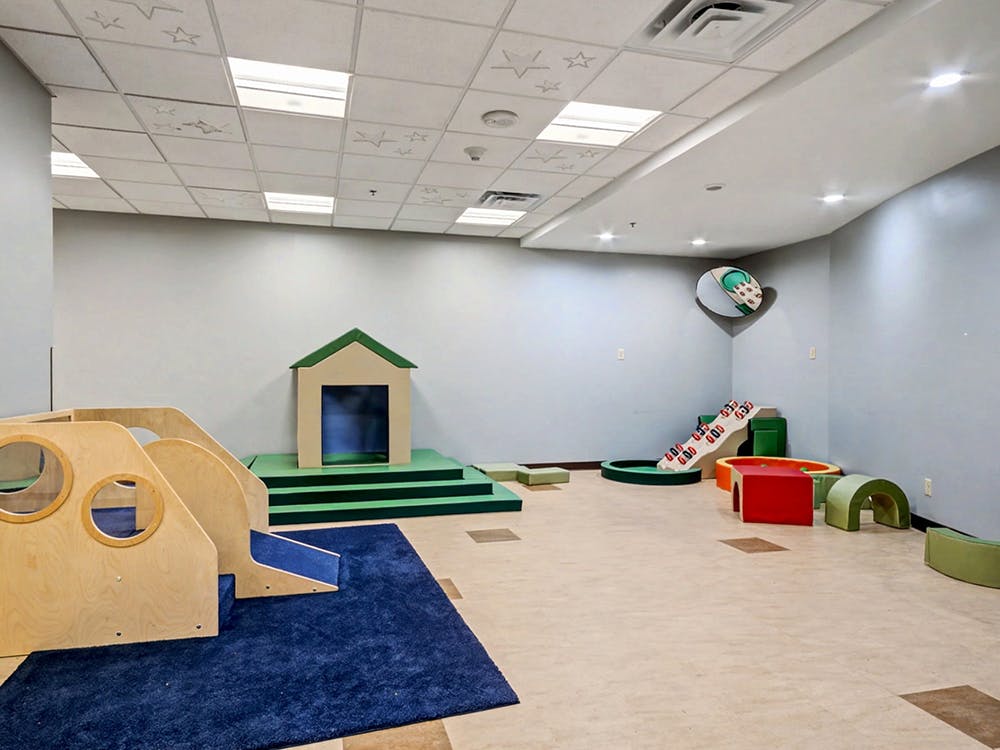 Indoor play area with soft play equipment and a playhouse