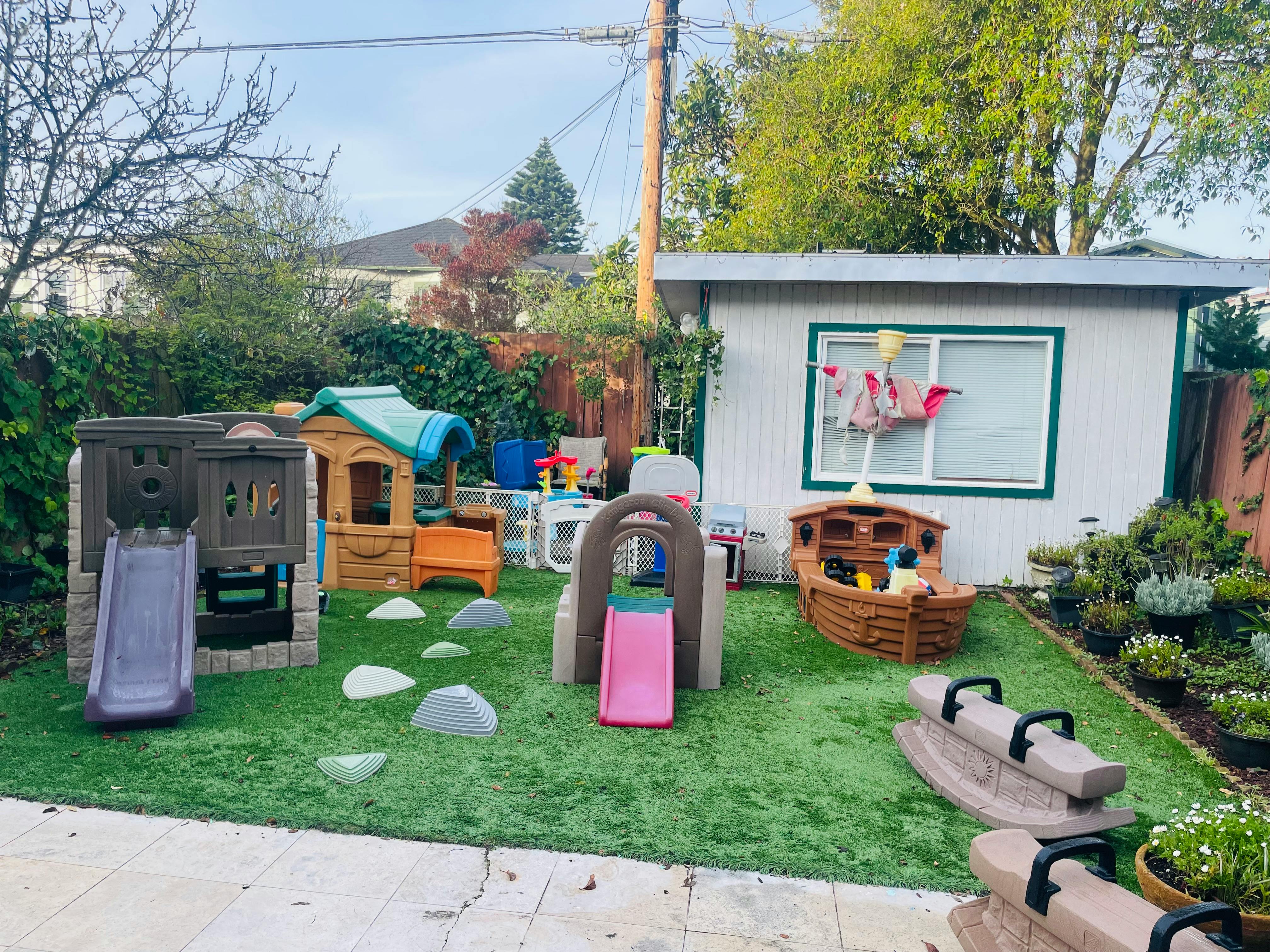 Playground with multiple play structures and slides on artificial turf