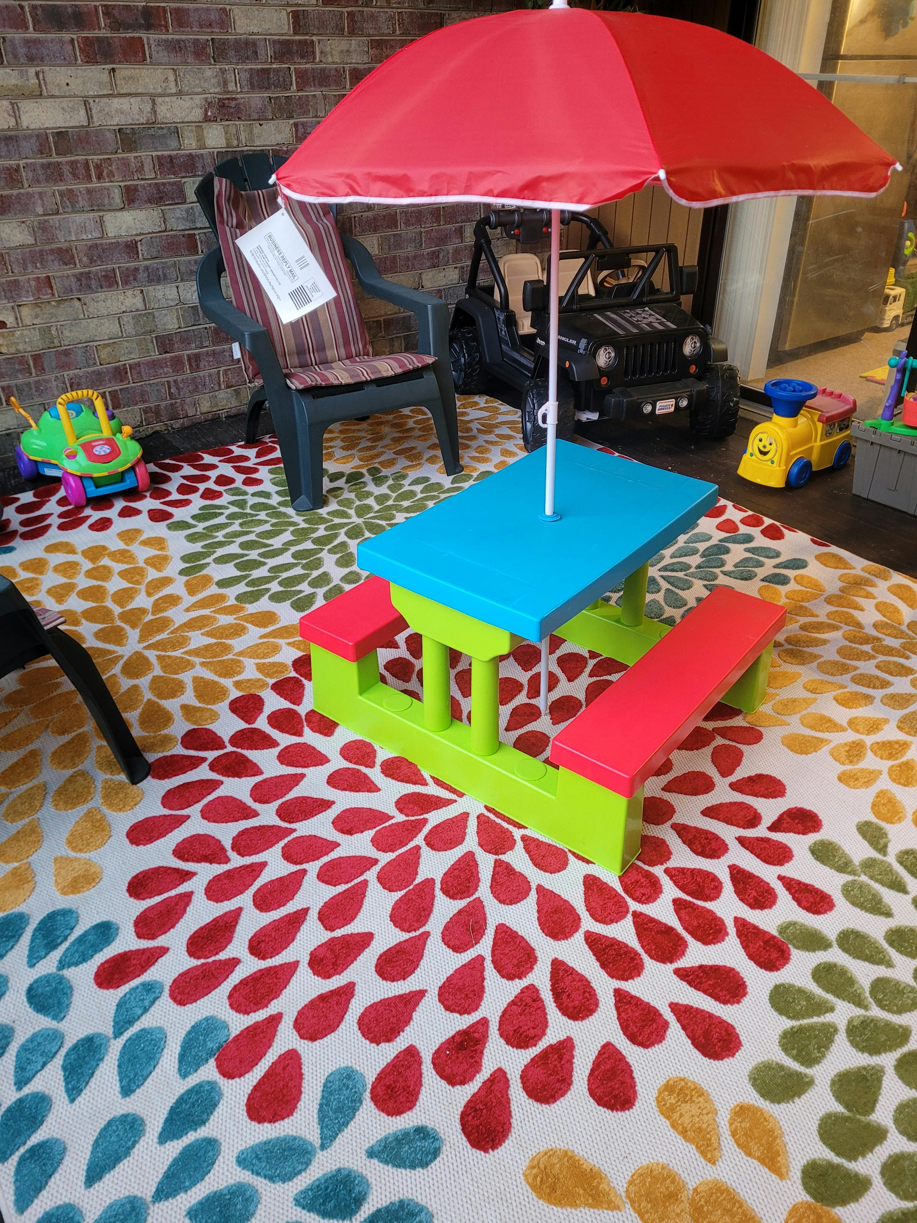Child's picnic table with umbrella on a patterned rug