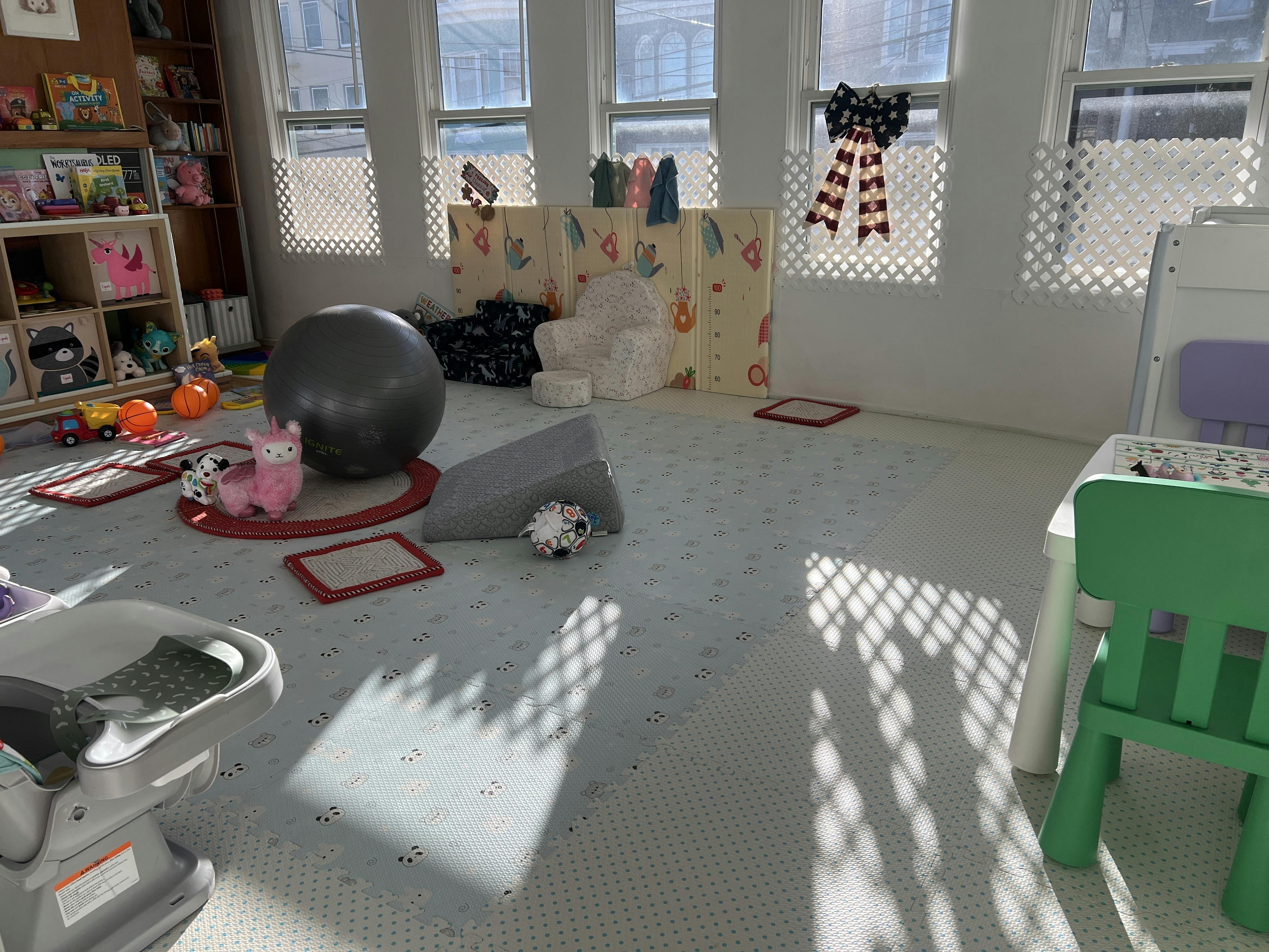 Playroom with toys, a large exercise ball, foam mats, and child-sized furniture