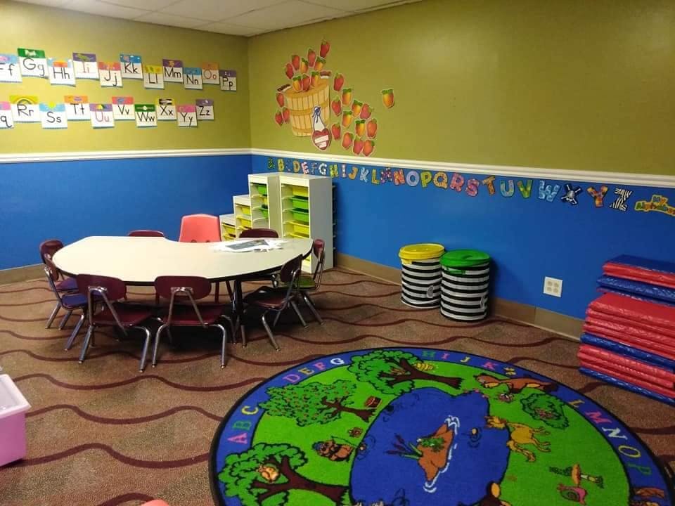 Children's classroom with tables, chairs, and colorful decorations