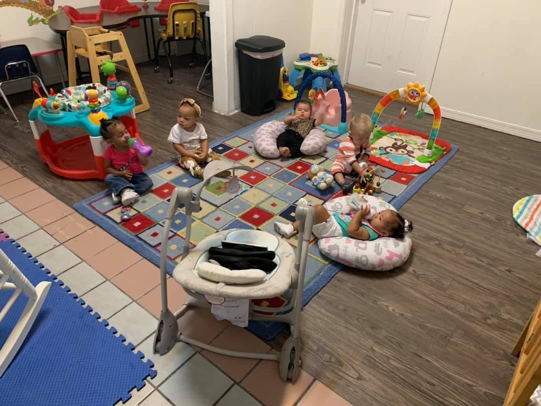 Multiple children playing on a rug with toys