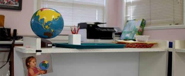 Globe on a desk with a picture of a child holding a globe