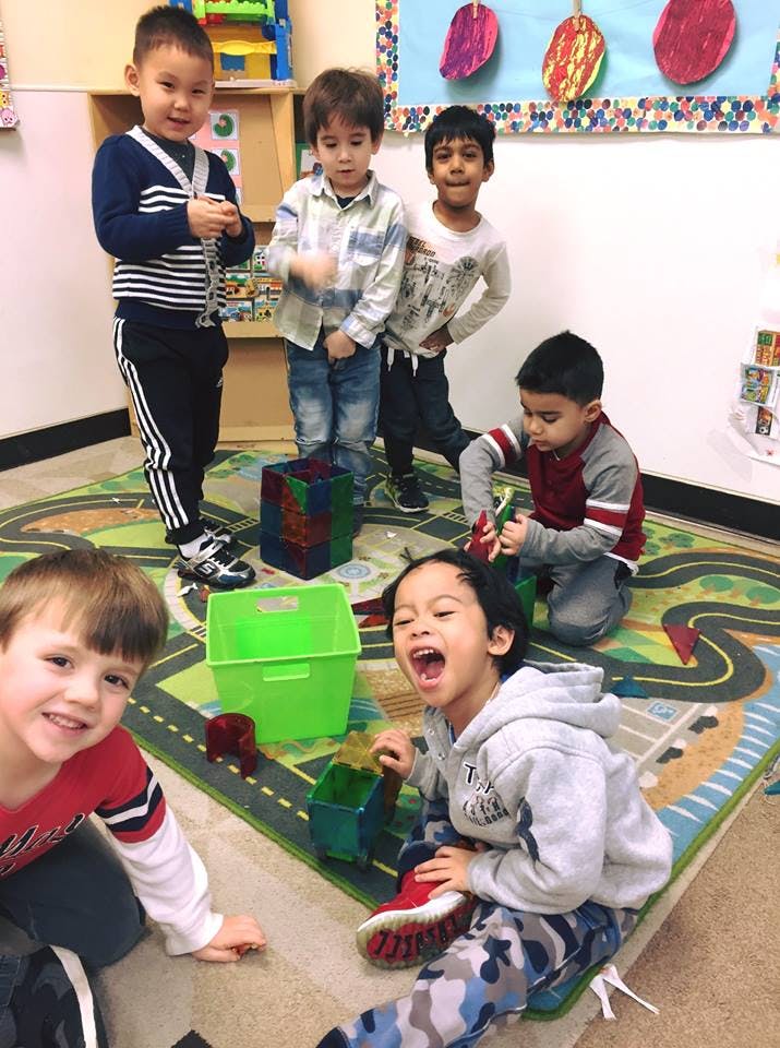 Group of children playing on a rug with toys