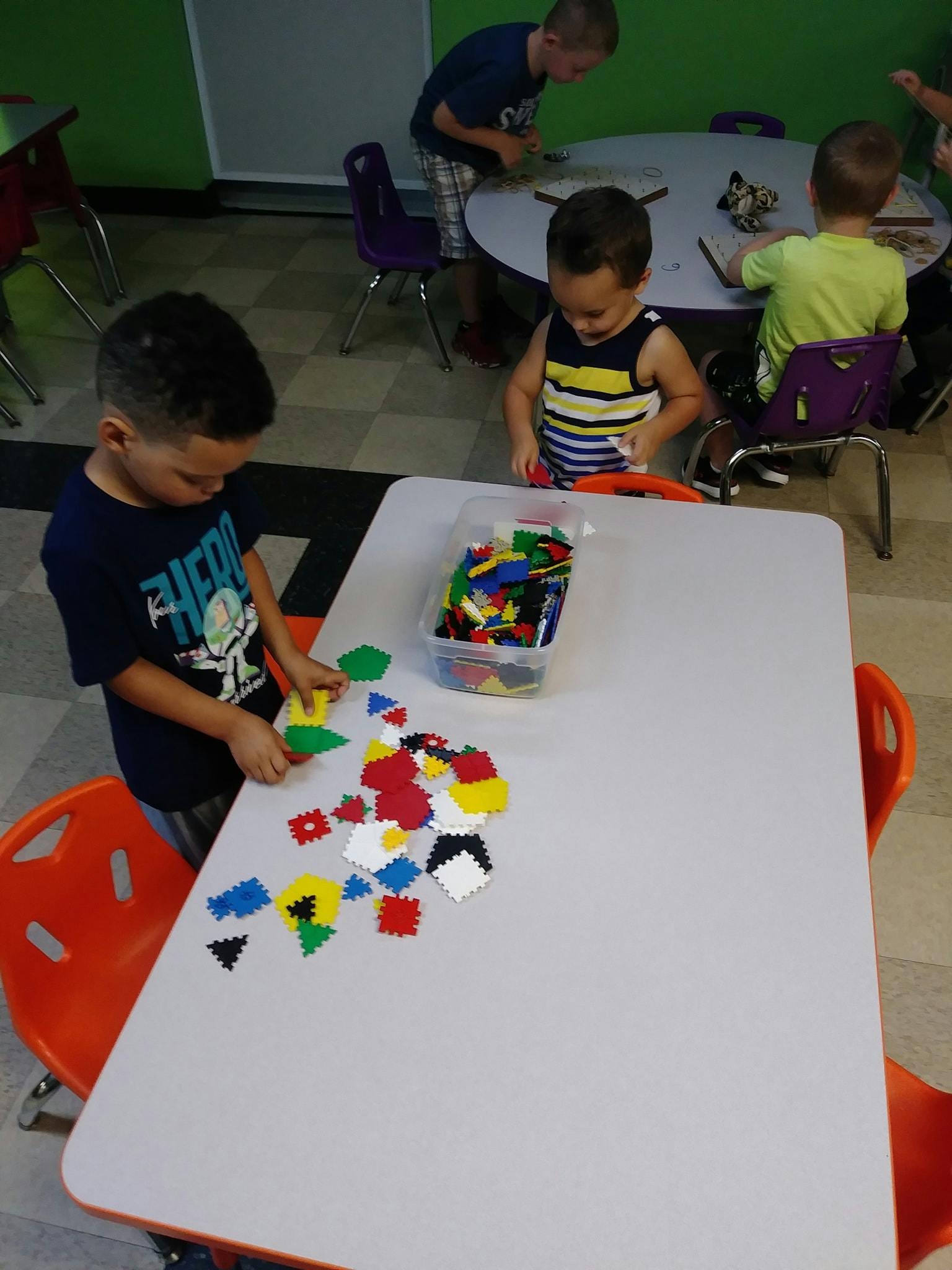Children playing with colorful building blocks at a table