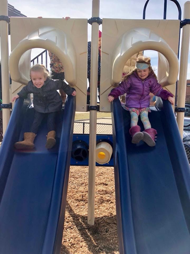 Two children on playground slides