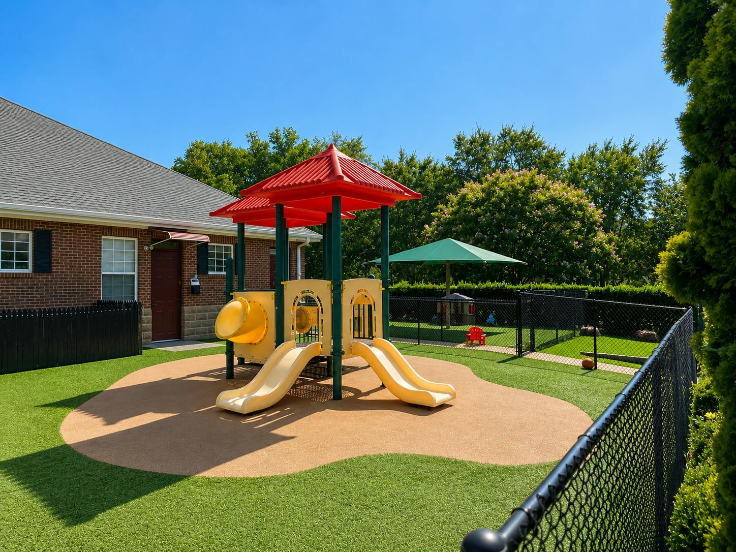 Playground structure with slides in a fenced yard
