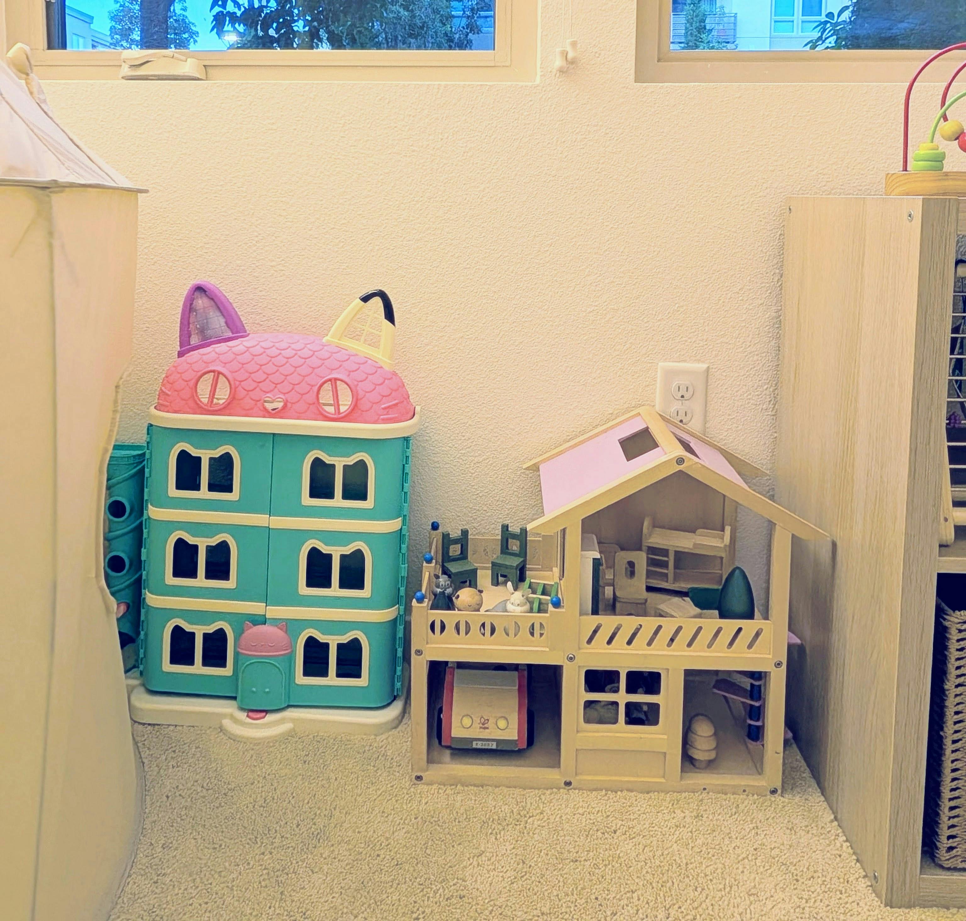 Cat-shaped toy storage and a wooden dollhouse in a room