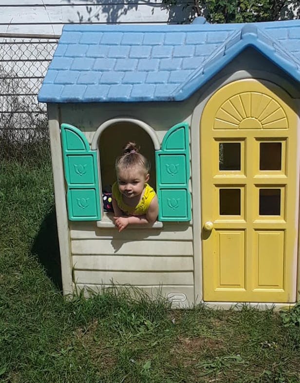 Child looking out of a playhouse window