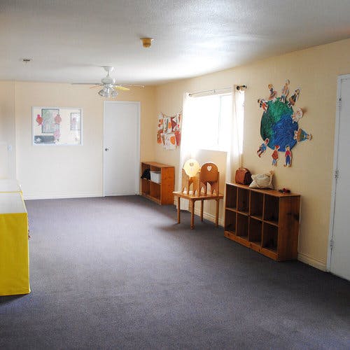 Empty classroom with a ceiling fan, window, and wall decorations
