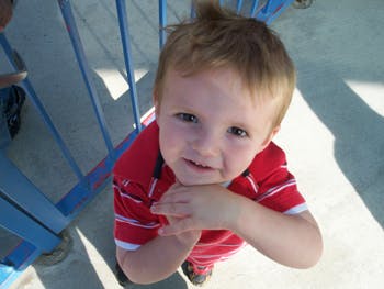 Child in red shirt looking up