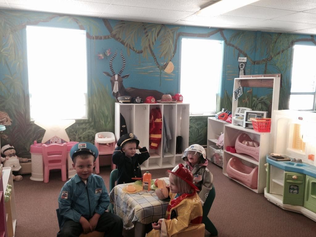 Children in costumes playing in a classroom
