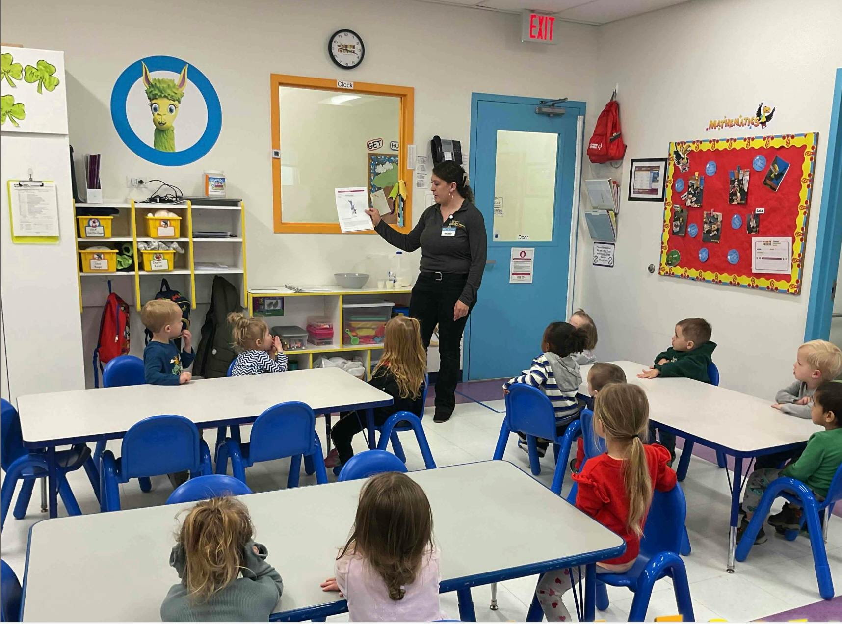 Person reading a book to children in a classroom