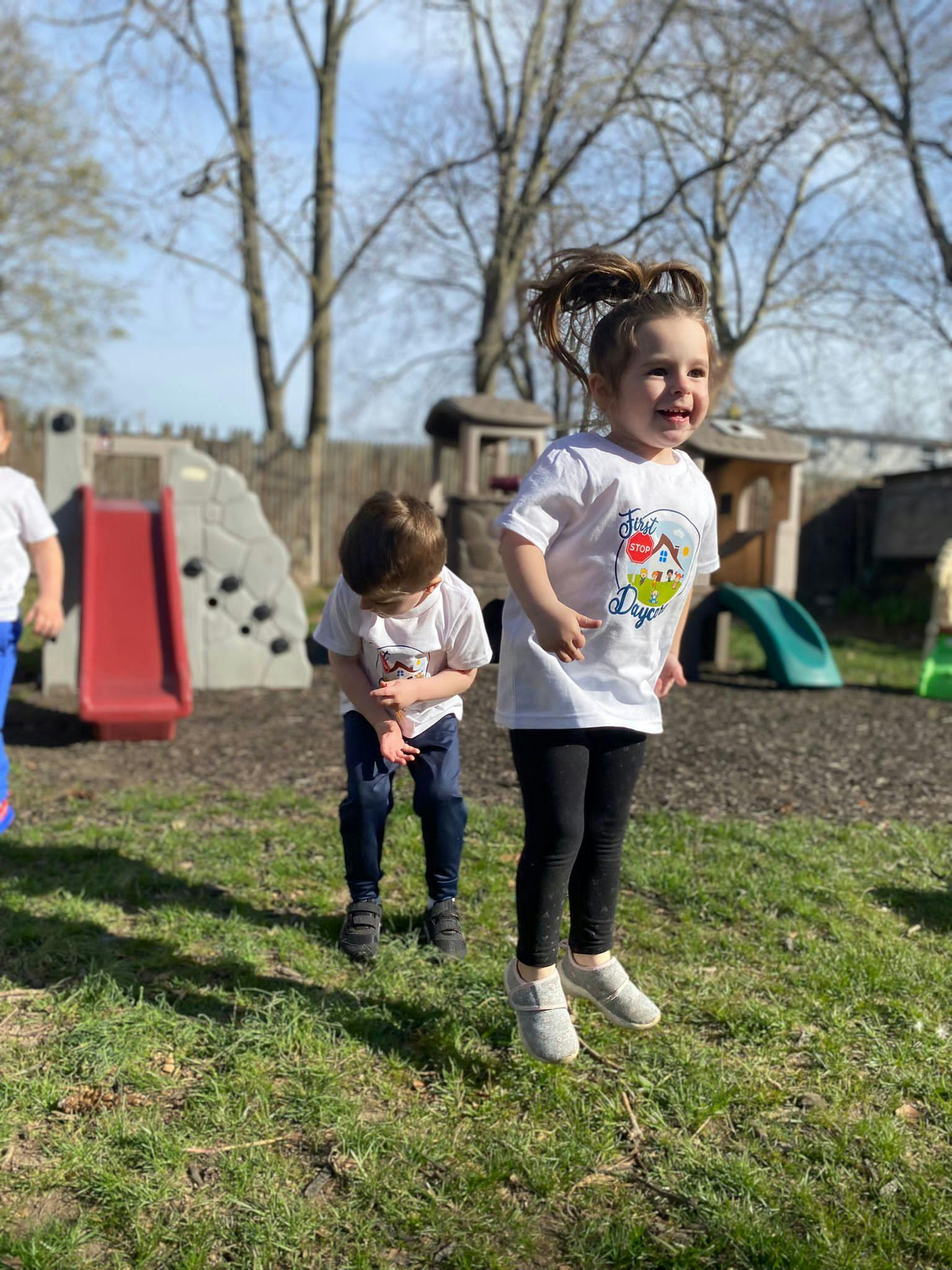 Child jumping in a playground with another child nearby