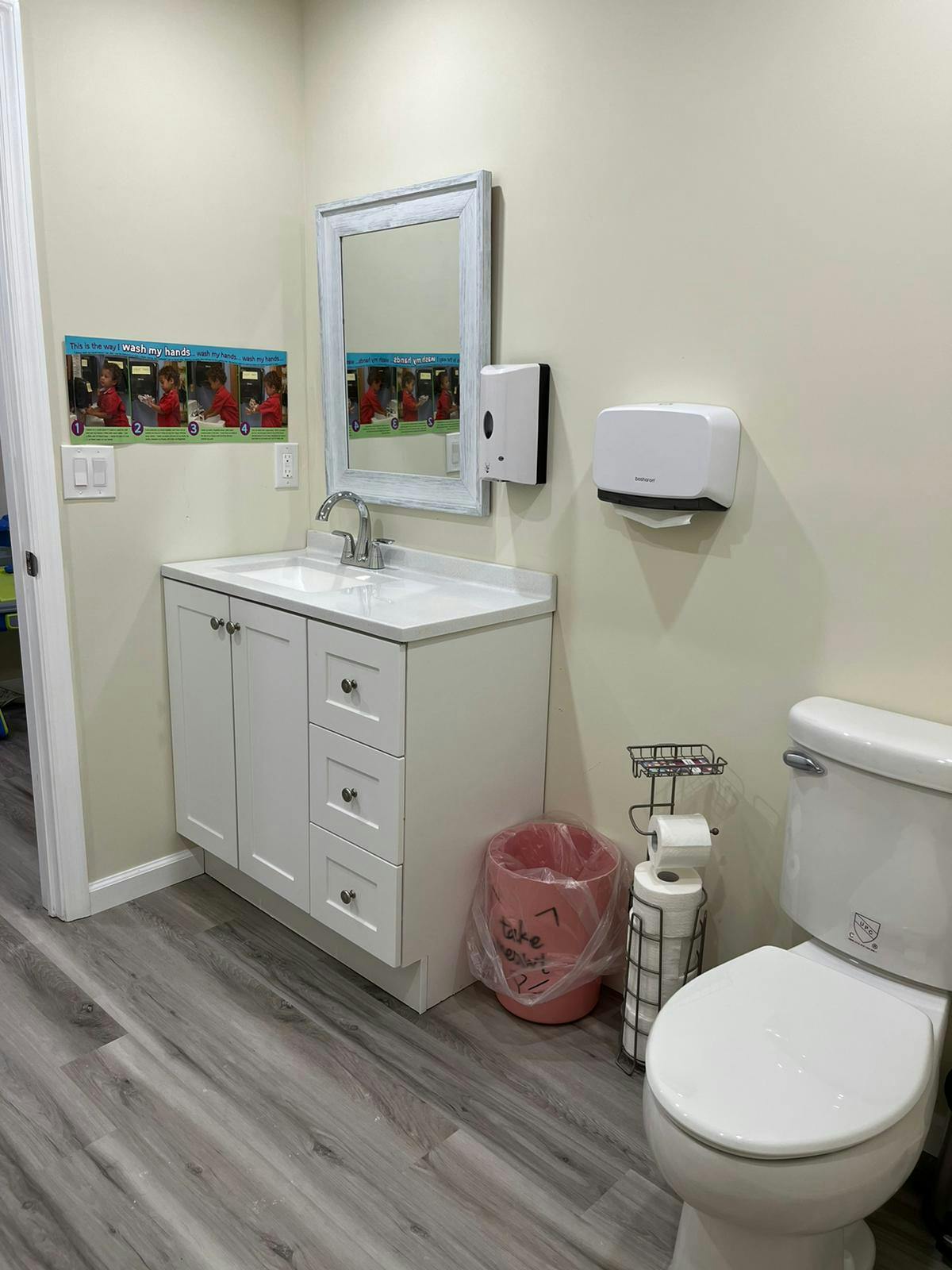Bathroom with a white vanity, sink, mirror, and toilet