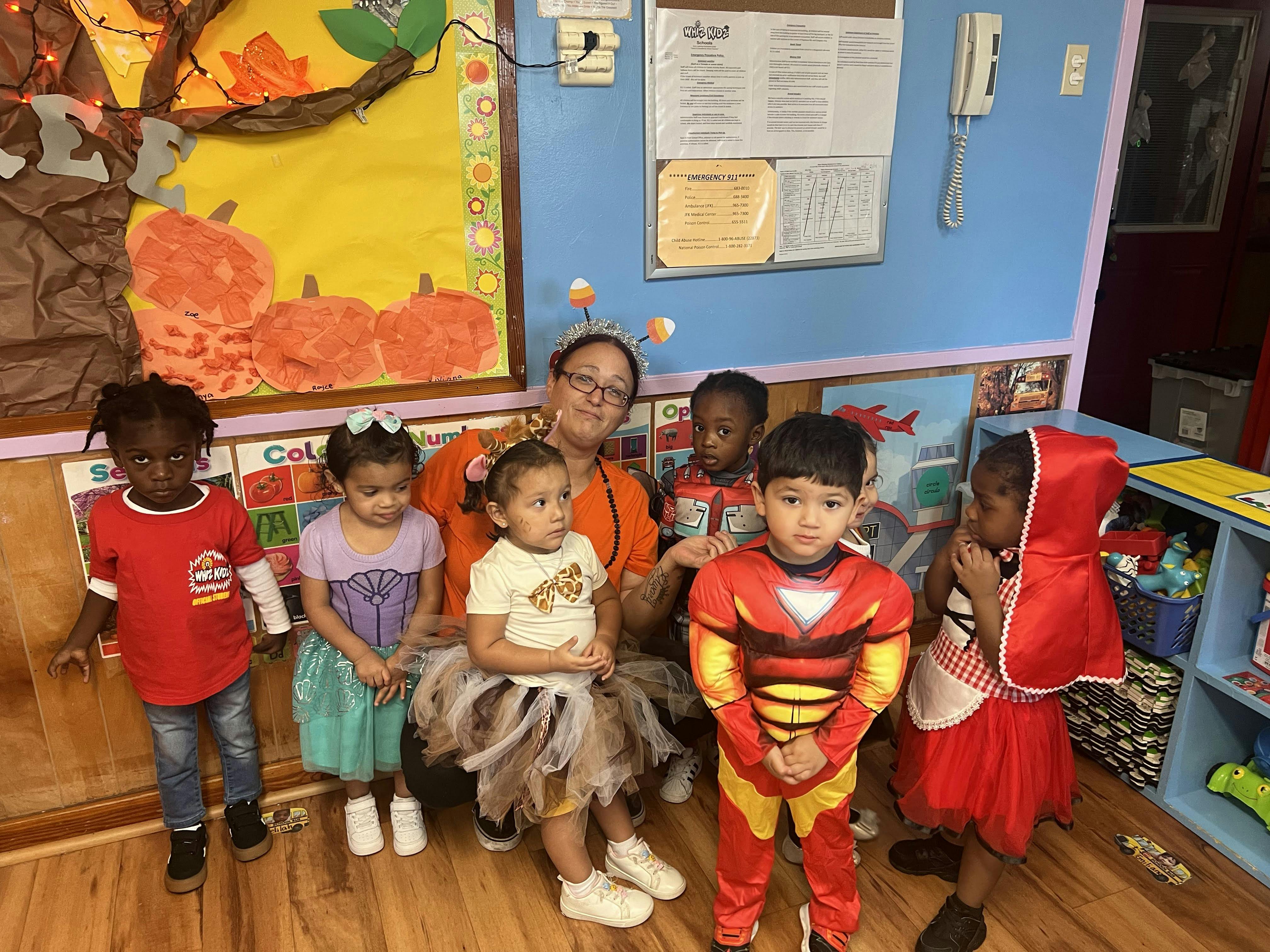 Adult and multiple children in costumes in a classroom