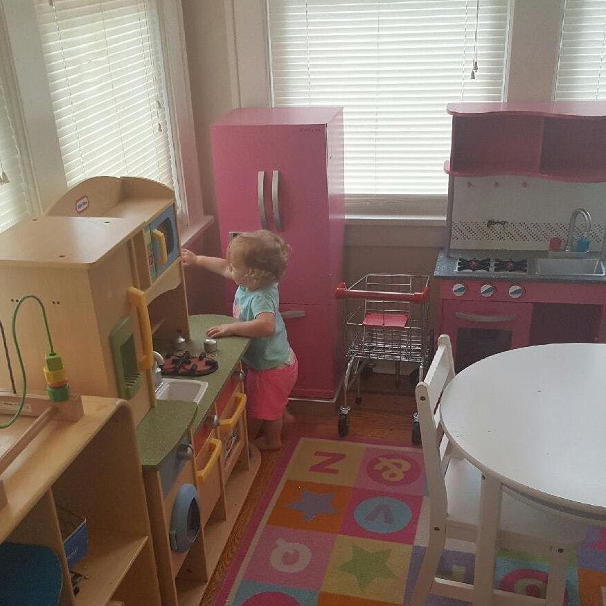 Child playing with a toy kitchen set