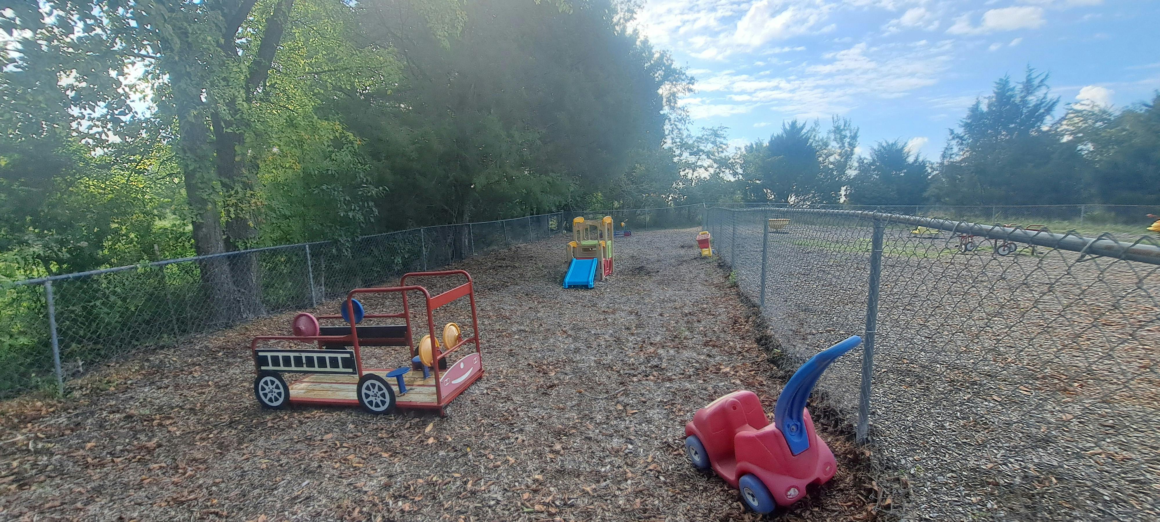 Outdoor playground with toy fire truck and other play equipment